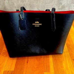 Coach black leather tote with red interior.